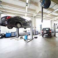 Auto repair shop in Pasadena, MD with customer vehicles on lifts, highlighting the need for Garage Insurance and Garagekeepers Insurance provided by Huff Insurance