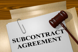 Gavel and subcontract agreement documents on a wooden table, signifying legal considerations for subcontracting - Huff Insurance in Pasadena, MD.