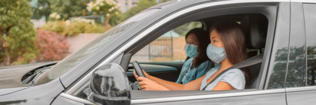 Page Title Image of Two passengers in a car, both wearing protective face masks, demonstrating safety measures that relate to the Communicable Disease Auto Insurance Exclusion topic. of the Huff Insurance blog