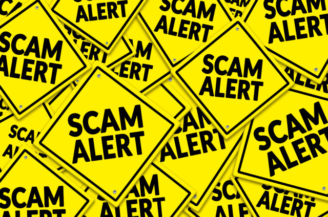 A cluster of bright yellow warning signs with bold black text reading 'SCAM ALERT' to symbolize vigilance against scams for the Huff Insurance Blog