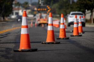 Summer driving hazards, Huff Insurance, Maryland - Stay safe with these essential tips for summer road trips. Image shows orange construction cones on a road, highlighting the dangers of construction zones